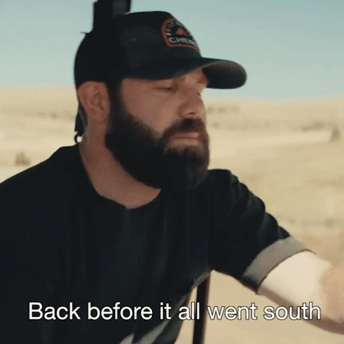 a man with a beard wearing a black hat with the words back before it all went south on the bottom