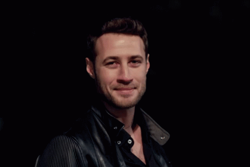 A Man With A Beard Wearing A Black Shirt And A Black Leather Jacket GIF