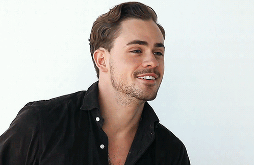A Man With A Beard Wearing A Black Shirt Smiles GIF