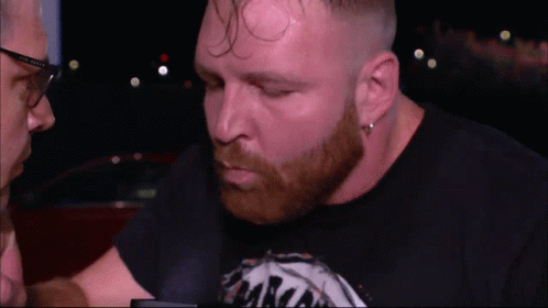 A Man With A Beard Wearing A Black Shirt That Says ' Aaron ' On It GIF