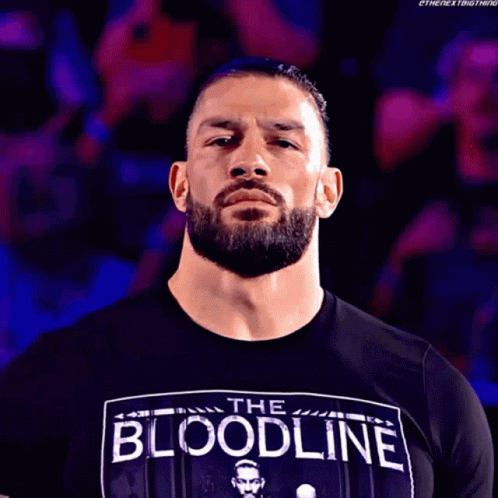 A Man With A Beard Wearing A Black Shirt That Says The Bloodline GIF