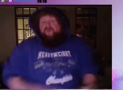 A Man With A Beard Wearing A Blue Heavyweight Hoodie Is Dancing . GIF