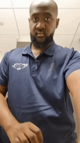 a man with a beard wearing a blue polo shirt that says ' velocity ' on it