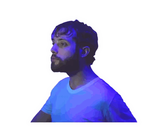 a man with a beard wearing a blue shirt looks to his left