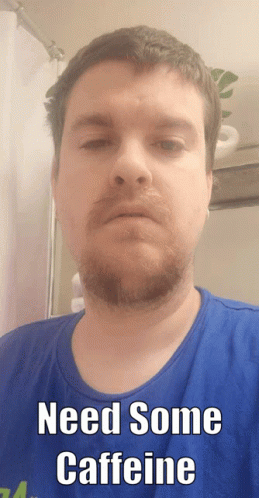 A Man With A Beard Wearing A Blue Shirt Says Need Some Caffeine GIF