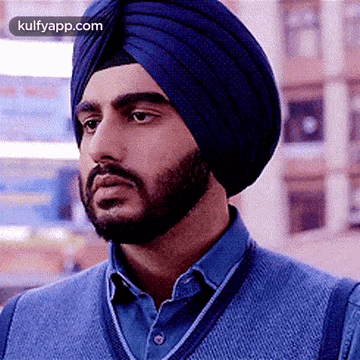 A Man With A Beard Wearing A Blue Turban And A Blue Sweater . GIF