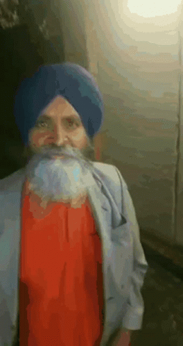 A Man With A Beard Wearing A Blue Turban And A Red Shirt GIF