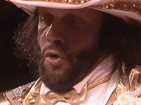 A Man With A Beard Wearing A Cowboy Hat And A Bow Tie With A W On His Chest GIF