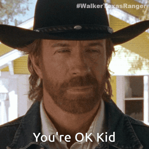 A Man With A Beard Wearing A Cowboy Hat And A Denim Jacket Says You 'Re Ok Kid GIF