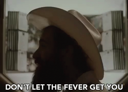A Man With A Beard Wearing A Cowboy Hat Says " Don 'T Let The Fever Get You " GIF