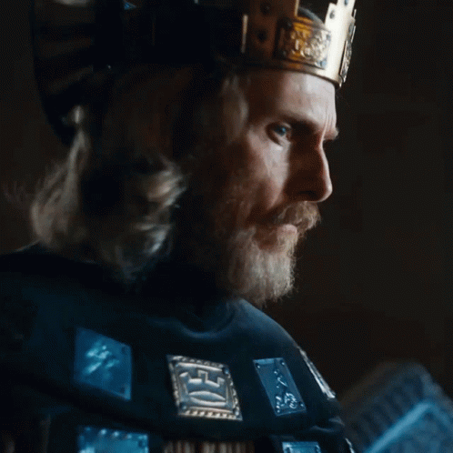 A Man With A Beard Wearing A Crown And A Black Shirt With The Word King On It GIF