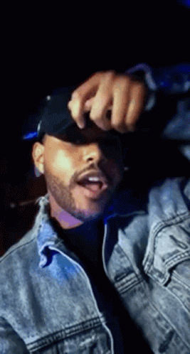 A Man With A Beard Wearing A Denim Jacket And A Black Hat . GIF