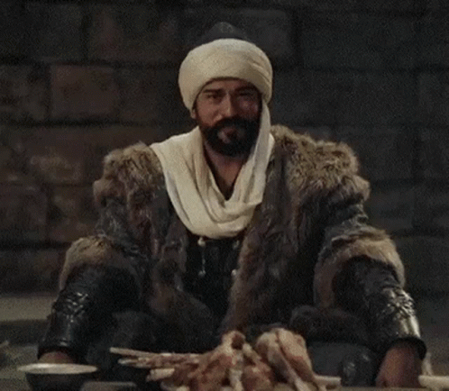 A Man With A Beard Wearing A Fur Coat And Turban . GIF