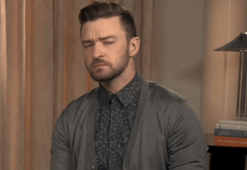 A Man With A Beard Wearing A Gray Cardigan GIF