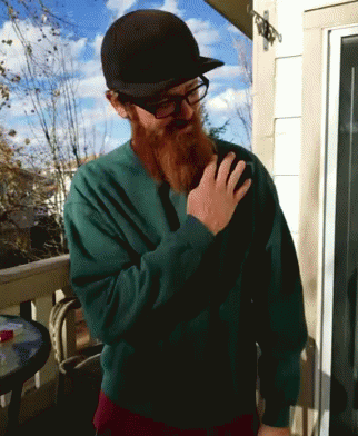 A Man With A Beard Wearing A Green Sweater And A Black Hat GIF