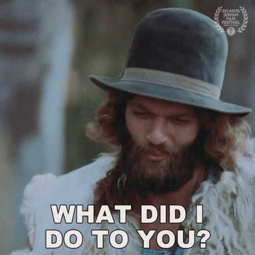 A Man With A Beard Wearing A Hat And A Fur Coat Says What Did I Do To You GIF