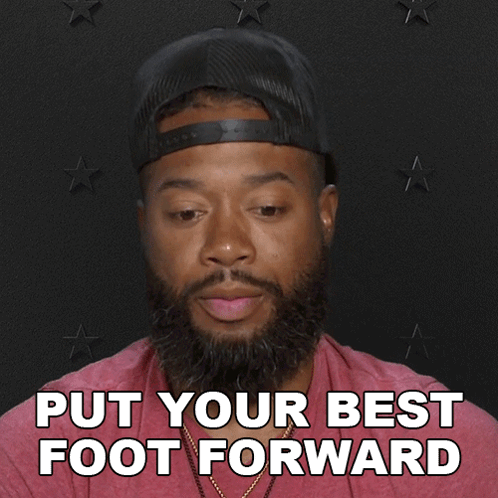 A Man With A Beard Wearing A Hat And A Red Shirt Says Put Your Best Foot Forward GIF