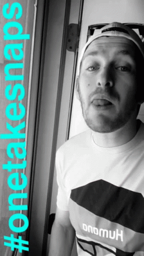 A Man With A Beard Wearing A Hat And A Shirt That Says Onemuk GIF