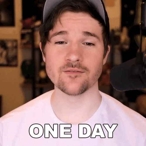 A Man With A Beard Wearing A Hat And A White Shirt That Says One Day GIF