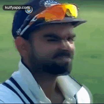 A Man With A Beard Wearing A Hat And Sunglasses Is Making A Funny Face . GIF