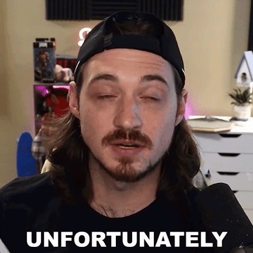 a man with a beard wearing a hat says " unfortunately " in front of a microphone