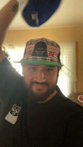 a man with a beard wearing a hat with a gorilla on it