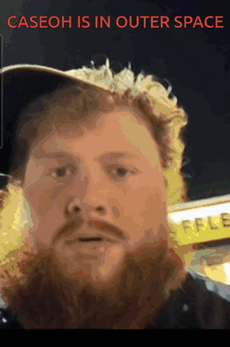 A Man With A Beard Wearing A Hat With The Words Caseoh Is In Outer Space Above Him GIF