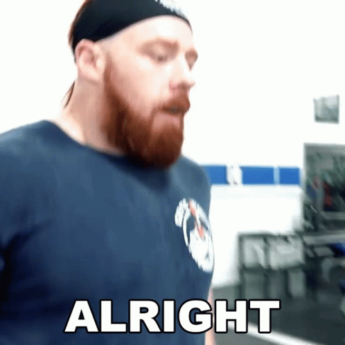 A Man With A Beard Wearing A Headband And A Blue Shirt Says Alright GIF