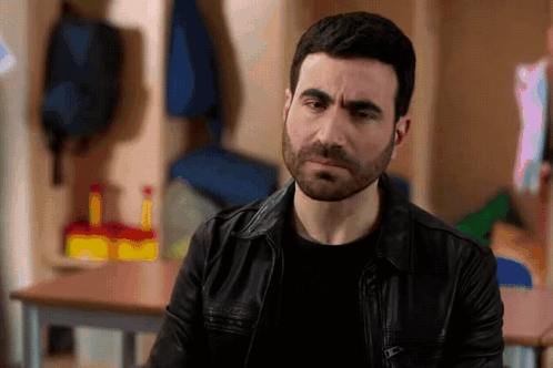 A Man With A Beard Wearing A Leather Jacket GIF