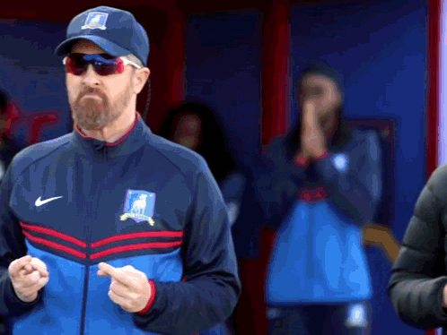 A Man With A Beard Wearing A Nike Hat And Jacket GIF