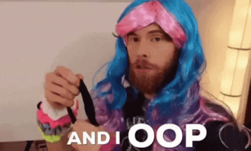 A Man With A Beard Wearing A Pink And Blue Wig Is Holding A Black Object And Says And I Oops GIF
