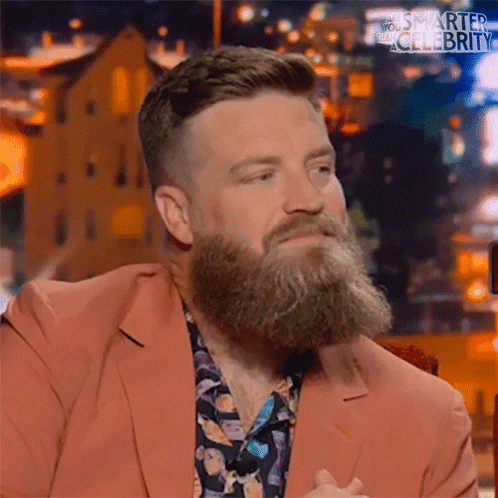 A Man With A Beard Wearing A Pink Suit And A Floral Shirt GIF