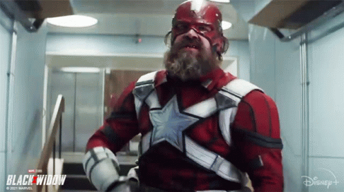 Bearded Man Standing In Hallway In Superhero Costume GIF