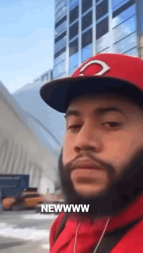 A Man With A Beard Wearing A Red Hat And A Red Hoodie Says Newwww GIF
