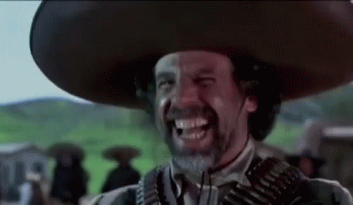A Man With A Beard Wearing A Sombrero And Holding A Gun Is Smiling . GIF