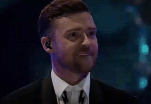 A Man With A Beard Wearing A Suit And Tie Is Making A Funny Face GIF