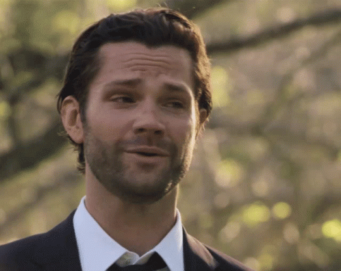 A Man With A Beard Wearing A Suit And Tie Is Smiling GIF