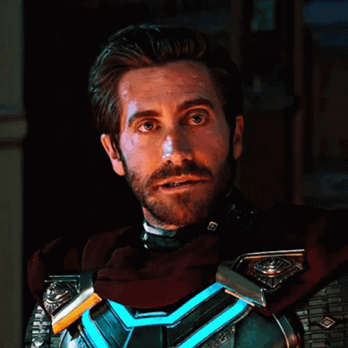 A Man With A Beard Wearing A Superhero Costume Is Looking At The Camera . GIF