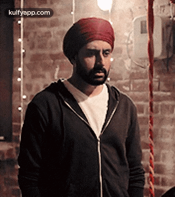 A Man With A Beard Wearing A Turban And A Black Jacket GIF