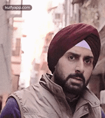 A Man With A Beard Wearing A Turban And A Vest . GIF