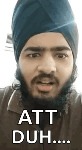 A Man With A Beard Wearing A Turban Is Making A Funny Face And Saying Att Duh . GIF