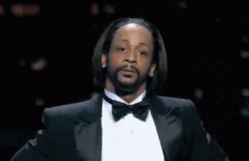 A Man With A Beard Wearing A Tuxedo And Bow Tie Is Making A Funny Face . GIF