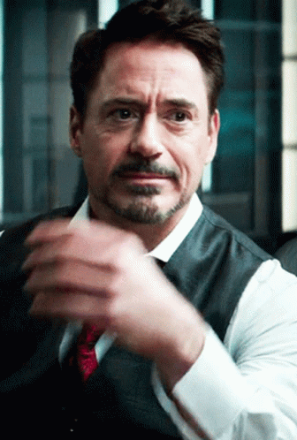 A Man With A Beard Wearing A Vest And Tie Is Clapping His Hands GIF