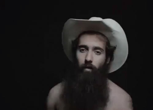 A Man With A Beard Wearing A White Cowboy Hat . GIF