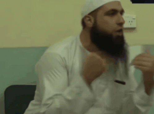 A Man With A Beard Wearing A White Hat And White Shirt GIF