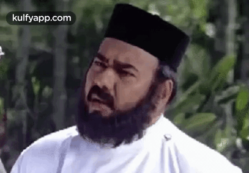 A Man With A Beard Wearing A White Shirt And A Black Hat . GIF