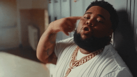A Man With A Beard Wearing A White Shirt And A Gold Necklace GIF