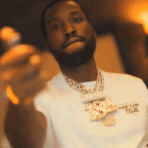A Man With A Beard Wearing A White Shirt And Gold Chains GIF