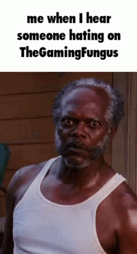 A Man With A Beard Wearing A White Tank Top Is Making A Funny Face . GIF