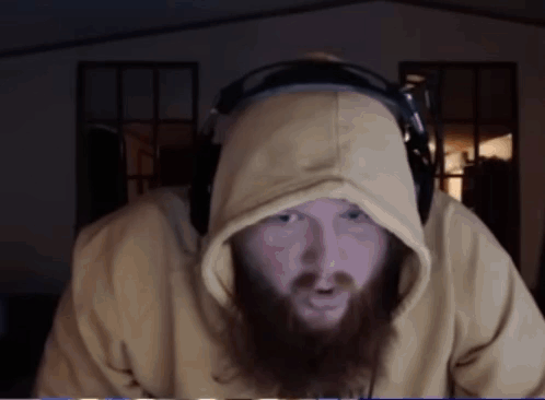 A Man With A Beard Wearing A Yellow Hoodie And Headphones GIF